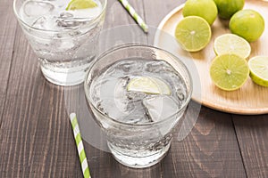 Fresh cocktail with soda, lime on a wooden background