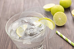 Fresh cocktail with soda, lime on a wooden background