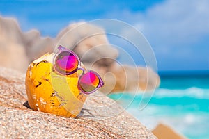 Fresh coconut cocktail and sunglasses on a tropical beach