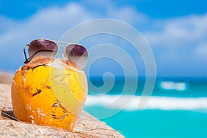 Fresh coconut cocktail and sunglasses on a tropical beach