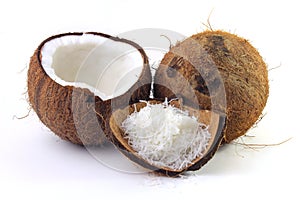 Fresh coconut flakes placed in bark and shell isolated on white background