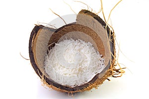 Fresh coconut flakes placed in bark and shell  on white background