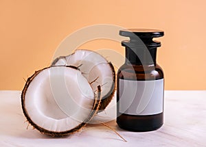 Fresh coconut half and  bottle of coconut oil mock up on  orange background on  marble white table