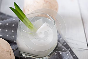 Fresh coconut juice in a glass with coconut white meat isolated on white