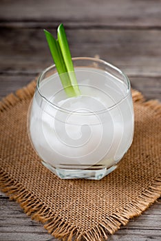 Fresh coconut juice in a glass with coconut white meat isolated on white