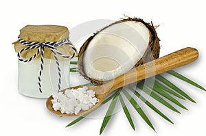 Fresh coconut oil in glassware and wooden spoon on a white backgroun