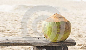 Fresh coconut water on The old wooden chair at beach in Phuket ,