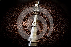 Fresh coffee beans and roasted spinning cover professional machine close up photo blur and dark background  long exposure shot