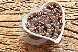 Fresh coffee beans in white heart cup