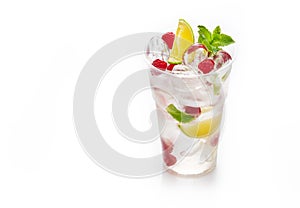 Fresh cold lemonade with soda, ice cubes, mint, lime and raspberry on white background