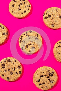 Fresh cookies with chocolate chips on a pink background. Dessert, a pastry shop. Pattern.