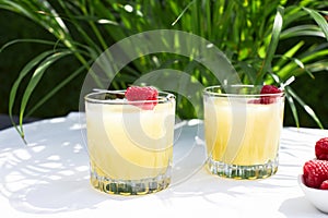 Fresh cool cocktail of melon with ice and lime slices, garnished with fresh raspberries. Summer drinks and smoothies