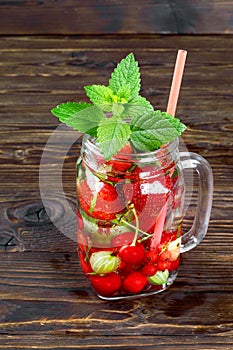 Fresh cool drink of ripe juicy cherry, strawberry, currant and gooseberry berries