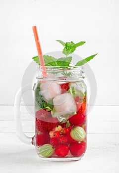 Fresh cool drink of ripe juicy cherry, strawberry, currant and gooseberry berries