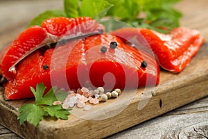 Fresh Copper River Salmon fillets on rustic wooden server with s