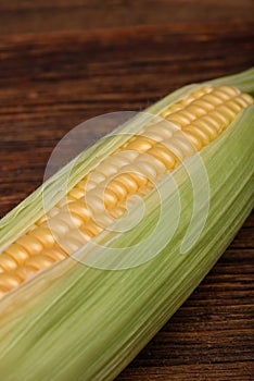 Fresh corn cob maize on the wooden table, top view closeup