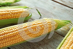 Fresh corn cobs on wooden background, closeup