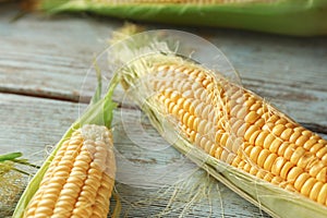 Fresh corn cobs on wooden background, closeup