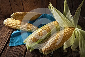 Fresh corn on cobs on wooden table
