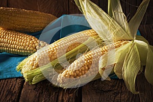 Fresh corn on cobs on wooden table