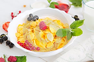 Fresh corn flakes with strawberries and milk close up Healthy tasty breakfast cornflakes with strawberries, raspberries