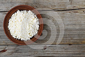 Fresh cottage cheese in a bowl on a wooden t