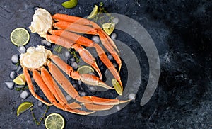 Fresh crab claws, lime, spices, spices, ice, shrimp, vegetables on a dark background. Delicious seafood, healthy food