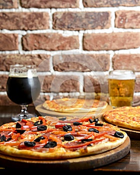 Fresh craft beer and pizza with vegetables and meat. Party concept, different kinds of pizza with delicious craft beer