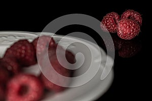 Fresh crimson raspberry  on black glass