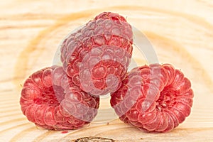 Fresh crimson raspberry on wood