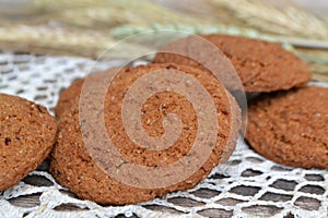 Fresh crispy cereal cookies and ears on knitted napkin and rustic wooden table