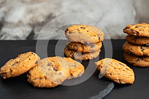 Fresh crispy chocolate chip cookies on a dark table