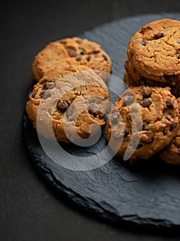 Fresh crispy chocolate chip cookies on a dark table