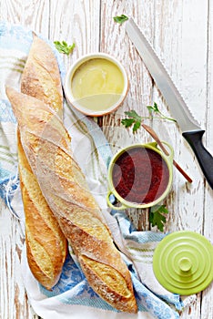 Fresh crispy French baguette with chicken liver pate and berry marmalade on a white aged background.