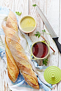 Fresh crispy French baguette with chicken liver pate and berry marmalade on a white aged background. photo
