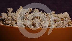 Fresh crispy popcorn drops in a bucket. Fresh hot popcorn drops in a bowl.