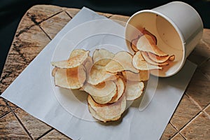 Fresh Crispy potato chips on a wooden background, top view.
