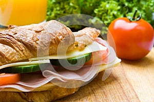 Fresh croissant with ham, cheese and salad