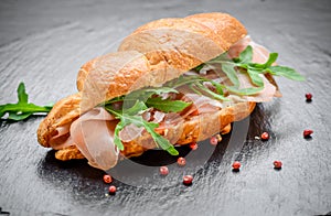 Fresh croissant with ham and salad leaf