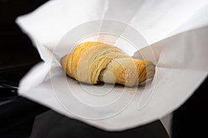 Fresh croissant in a paper bag