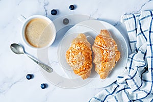 Fresh croissants with berries and cup of coffee