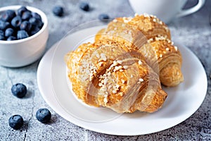 Fresh croissants with berries and cup of coffee