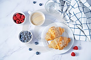 Fresh croissants with berries and cup of coffee