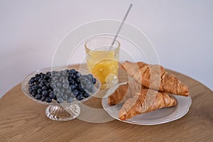 Fresh croissants with blueberries and orange juice