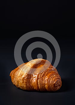 Fresh croissants bread and a cup of coffee on black background.