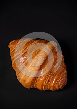 Fresh croissants bread and a cup of coffee on black background