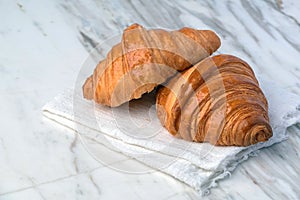 Fresh croissants bread on marble table.