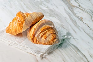 Fresh croissants bread on marble table.