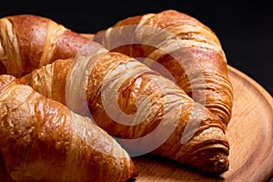 Fresh croissants on a cutting board close-up. French cuisine concept