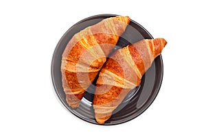 Fresh croissants in a plate on a white background. Top view